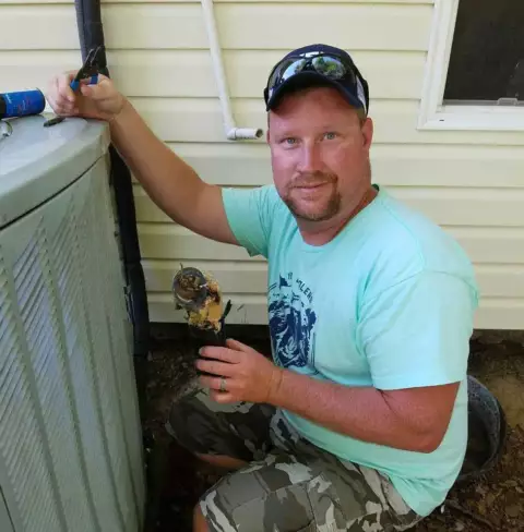 Owner Chris Dutton working on a customer's air conditioning unit.